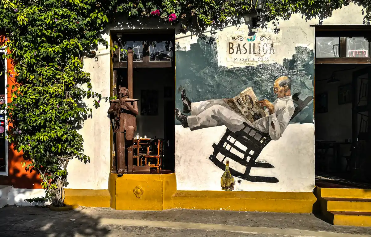 Pizzeria cafe storefront with a hand-painted mural integrated into the building facade