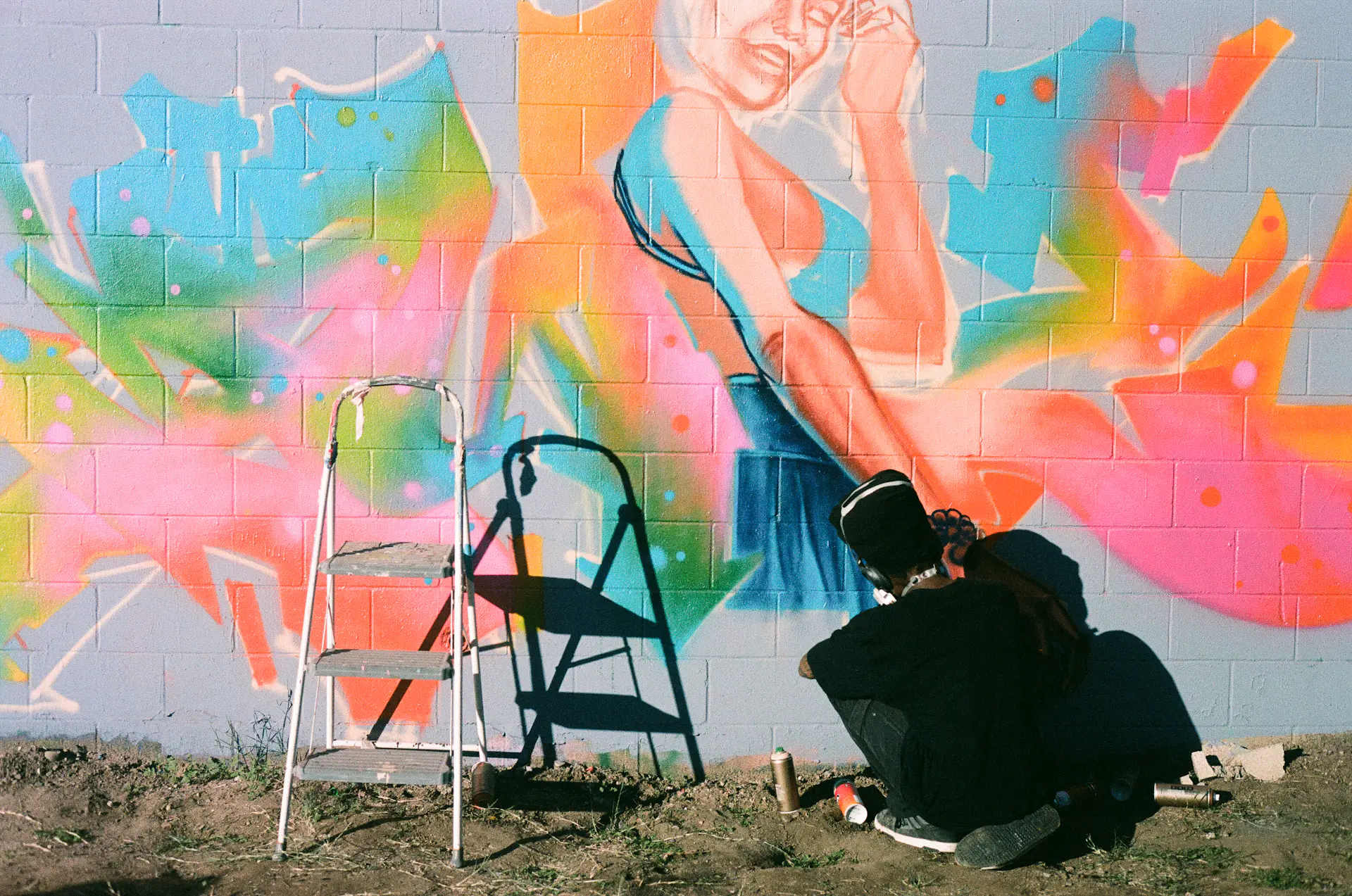 Mural artist painting a vibrant wall mural