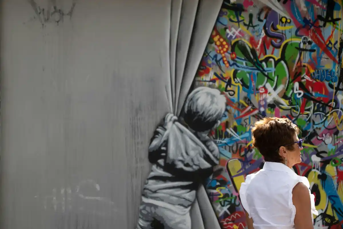 Person experiencing a large-scale street art mural up close